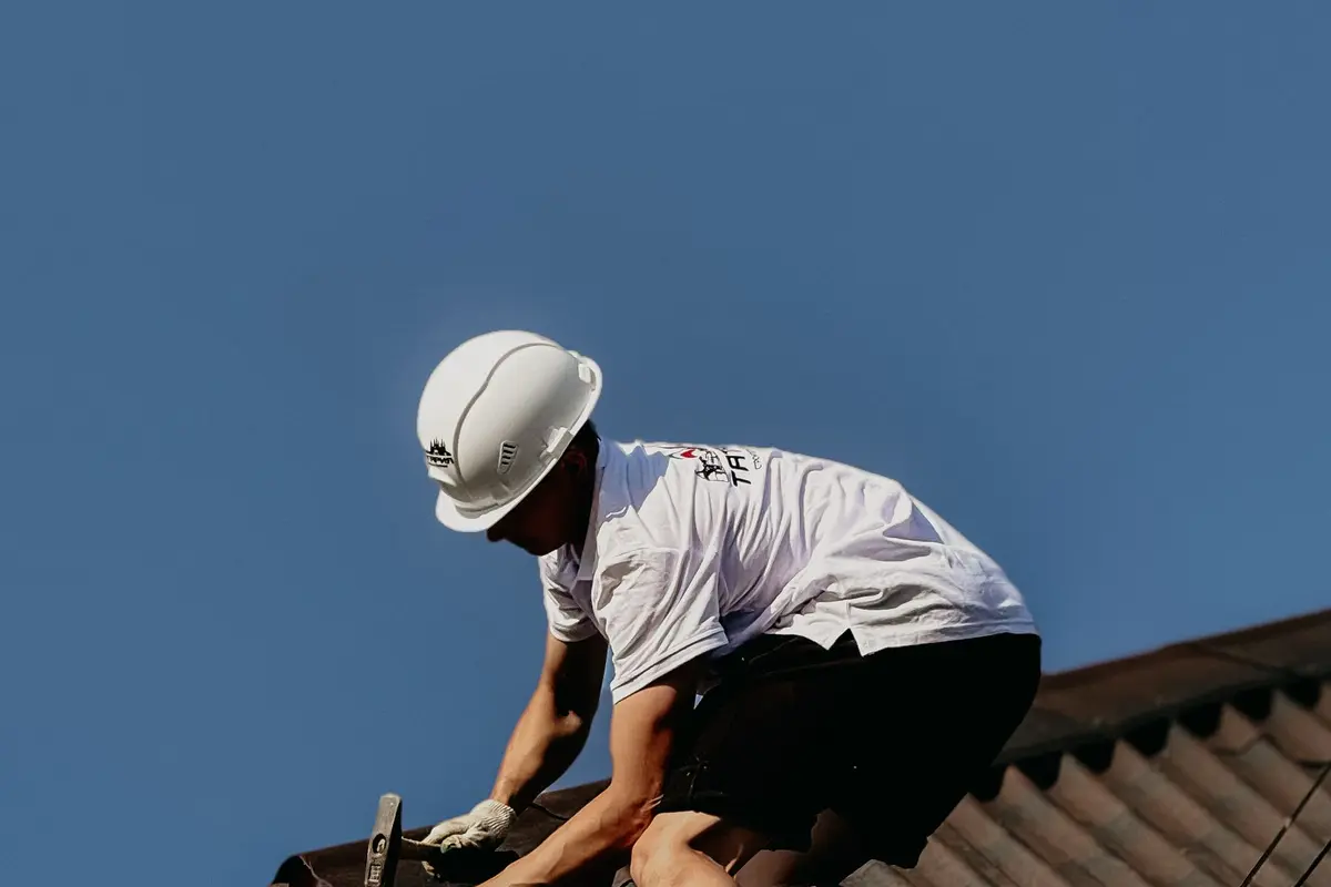 Dakdekker met helm aan het werk op een dak