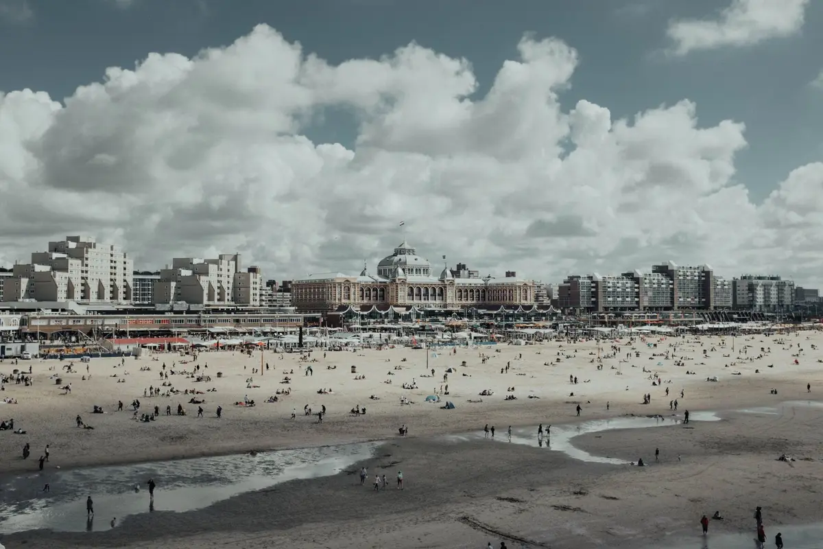 Strand van Scheveningen met mensen en het Kurhaus op de achtergrond