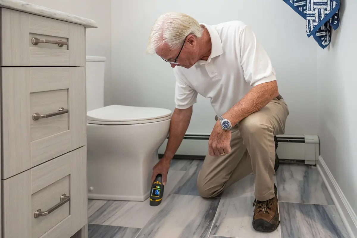 Vakman knielt naast de wc in een badkamer