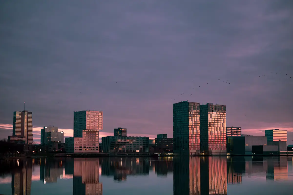 Skyline van Almere Stad in de schemering, weerspiegeld in het Weerwater