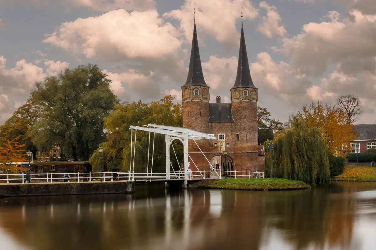 De Oostpoort in Delft met de witte ophaalbrug, weerspiegeld in het water
